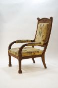 A large Arts & Crafts oak armchair with curving arms on block legs and stylised tulip patterned