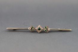 An early 20th century gold, emerald and diamond knife-edge bar brooch,