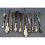 A collection of six shoe horns with silver handles together with four button hooks,