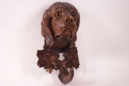 A Black Forest style carved dog's head wall hook with glass eyes,