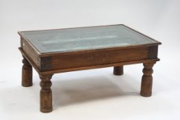 An Indian hardwood coffee table with glass top, 46cm high x 98cm wide x 67.