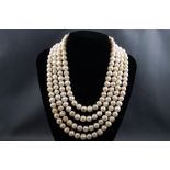 A large four strand cultured freshwater pearl necklace with base metal paste stone clasp.