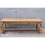 A substantial pine kitchen table on turned legs,