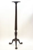A William IV mahogany torchere with carved palmette and reeded column on claw and ball feet,