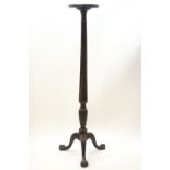 A William IV mahogany torchere with carved palmette and reeded column on claw and ball feet,