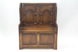 A small 20th century hall bench with storage seat, the back carved with arch decoration,