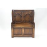 A small 20th century hall bench with storage seat, the back carved with arch decoration,