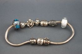 A Pandora white metal bracelet, stamped '925' with seven assorted charms,