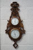 A Victorian double barometer and clock, set in an oak surround carved as foliage and a ribbon bow,