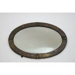 An Arts & Crafts oval wall mirror with silvered copper surround, 41cm x 56.