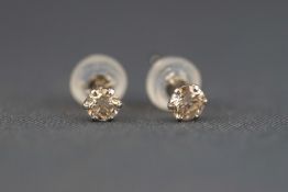 A white metal pair of single stone diamond stud earrings. Stated weight of 0.15ct each.
