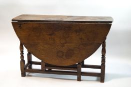An early 19th century oak gateleg table on turned and block supports,