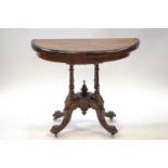 A Victorian walnut demi-lune card table with marquetry top on four column supports and ceramic