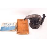 A WWII signal lamp with a 1942 ediion of Stand Notes for Wireless Mechanic and Signals for the Home