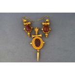 An Etruscan style pendant and matching pair of earrings, both set with carved agate.