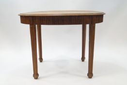 An early 20th century oval oak table with reeded detail to apron and legs, on spade feet,