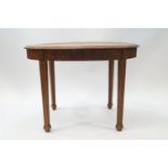 An early 20th century oval oak table with reeded detail to apron and legs, on spade feet,