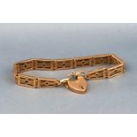 A hallmarked 9 carat gold gate style bracelet with padlock and safety chain. 17.