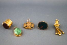 A selection of gold charms to include a bloodstone seal (uncarved), a Maltese cross, a gold tassel,