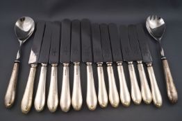 A set of six silver handled table knives, six dessert knives and a pair of salad servers,