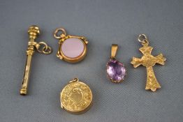 A selection of five gold charms to include a citrine baton, a gold locket,