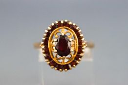 A yellow metal garnet cluster ring, Hallmarked 9ct gold, London, 1978. Size; P 3.