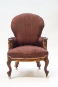 A Victorian mahogany nursing chair with foliate scroll arms,