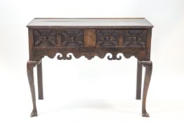 A 17th century style oak two drawer side table, the drawers with inlay and geometric carving,