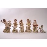 A set of Capodimonte porcelain figures of putli playing musical instruments, each on scroll bases,