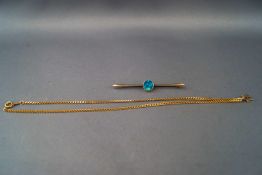 A yellow metal bar brooch set with blue/green opal. Stamped for 9ct gold.