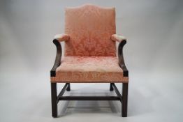 A George III style mahogany armchair on outward curving front supports,