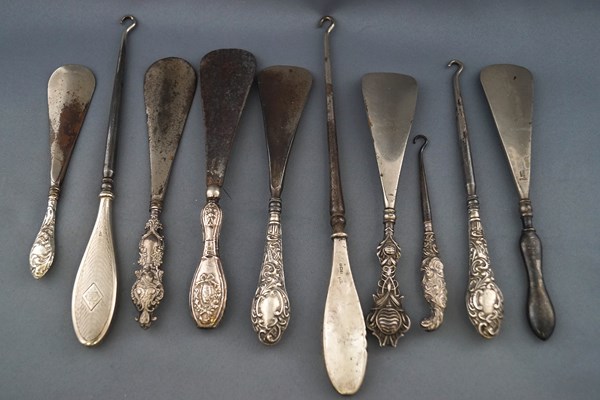 A collection of six shoe horns with silver handles, together with four button hooks,