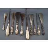 A collection of six shoe horns with silver handles, together with four button hooks,