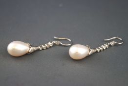 A white metal pair of drop earrings each set with rose cut and round brilliant diamonds and