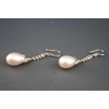 A white metal pair of drop earrings each set with rose cut and round brilliant diamonds and