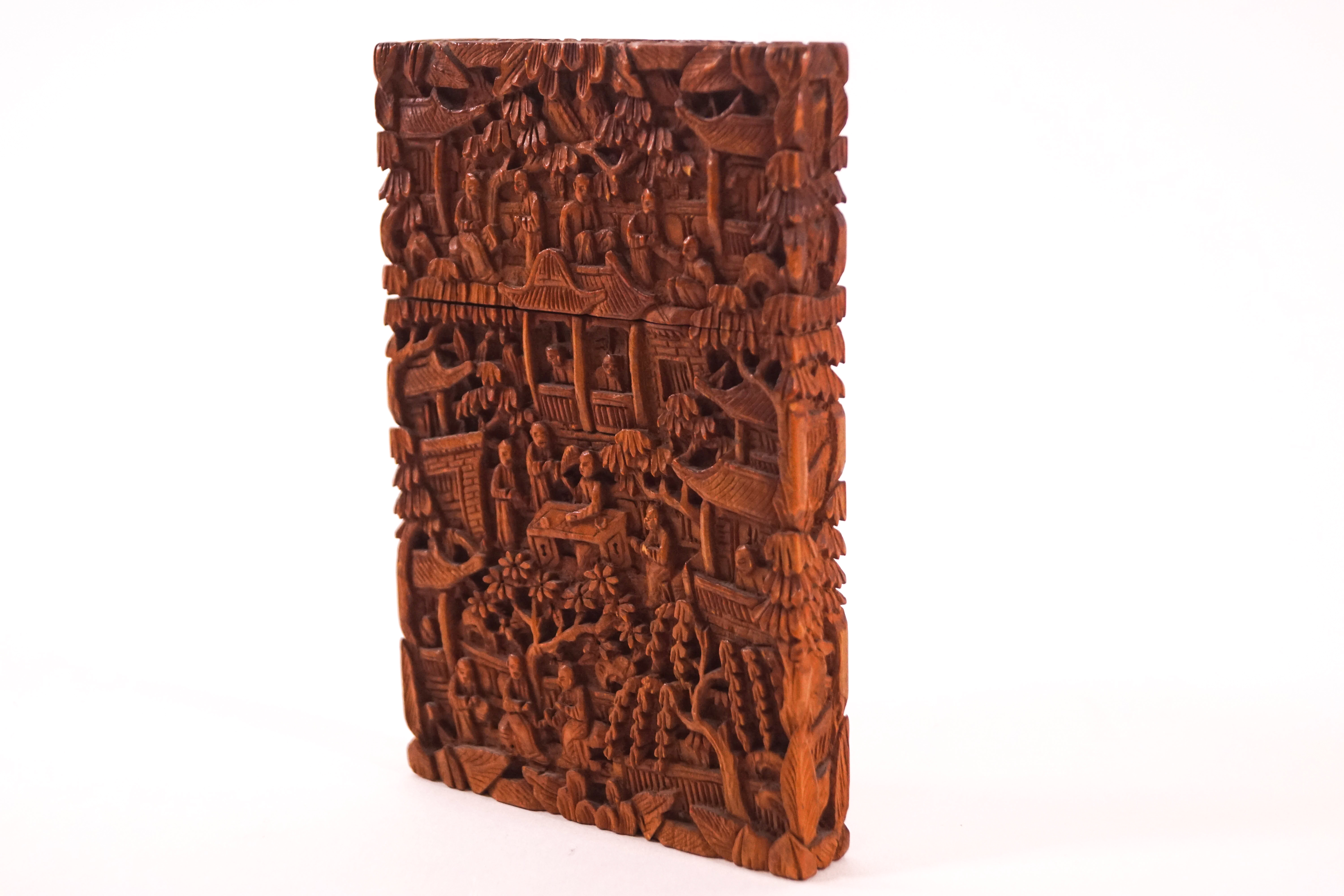A Chinese wooden card case, carved in low relief with figures and pagodas, 11.5cm x 7.
