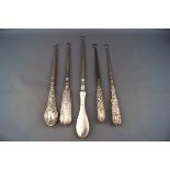 Five silver handled button hooks,