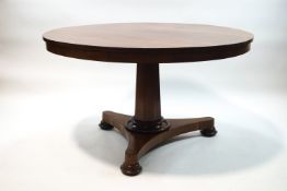 A William IV mahogany tilt top breakfast table on inverted octagonal column and triform base,