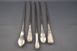 Five silver handled button hooks, comprising; a plain example with a shaped wavy handle,