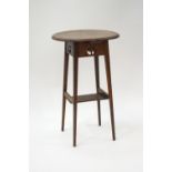 An Arts & Crafts oak occasional table with under-shelf and pierced flower motifs on tapering legs,