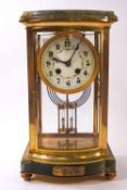 An early 20th century green marble and four glass sided mantel clock with eight day movement and