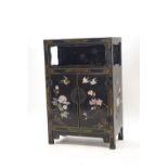 A Chinese lacquered and gilded cupboard with applied hardstone decoration in the form of birds and