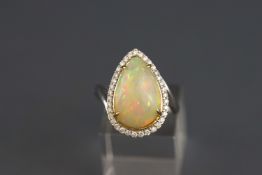 A white metal opal and diamond cluster ring. Estimated weight of (1) Opal 4.40 carats.