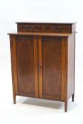 An Edwardian mahogany and inlaid side cupboard with two small drawers over oval inlaid doors,