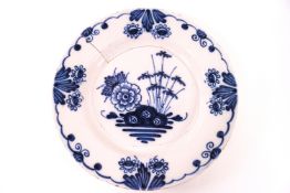 An 18th century Delft tin glazed plate, painted with flowers in blue,