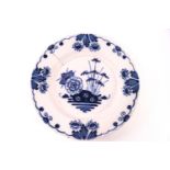 An 18th century Delft tin glazed plate, painted with flowers in blue,