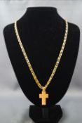 A yellow metal flattened curb link chain and Crucifix pendant, both stamped "750",