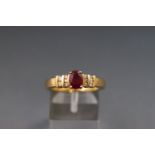 A yellow metal dress ring set with a single ruby and ten diamonds. Hallmarked 18ct gold, Birmingham.