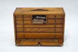 An oak engineer's cabinet, containing various tools, including lathe bits, callipers, dividers,