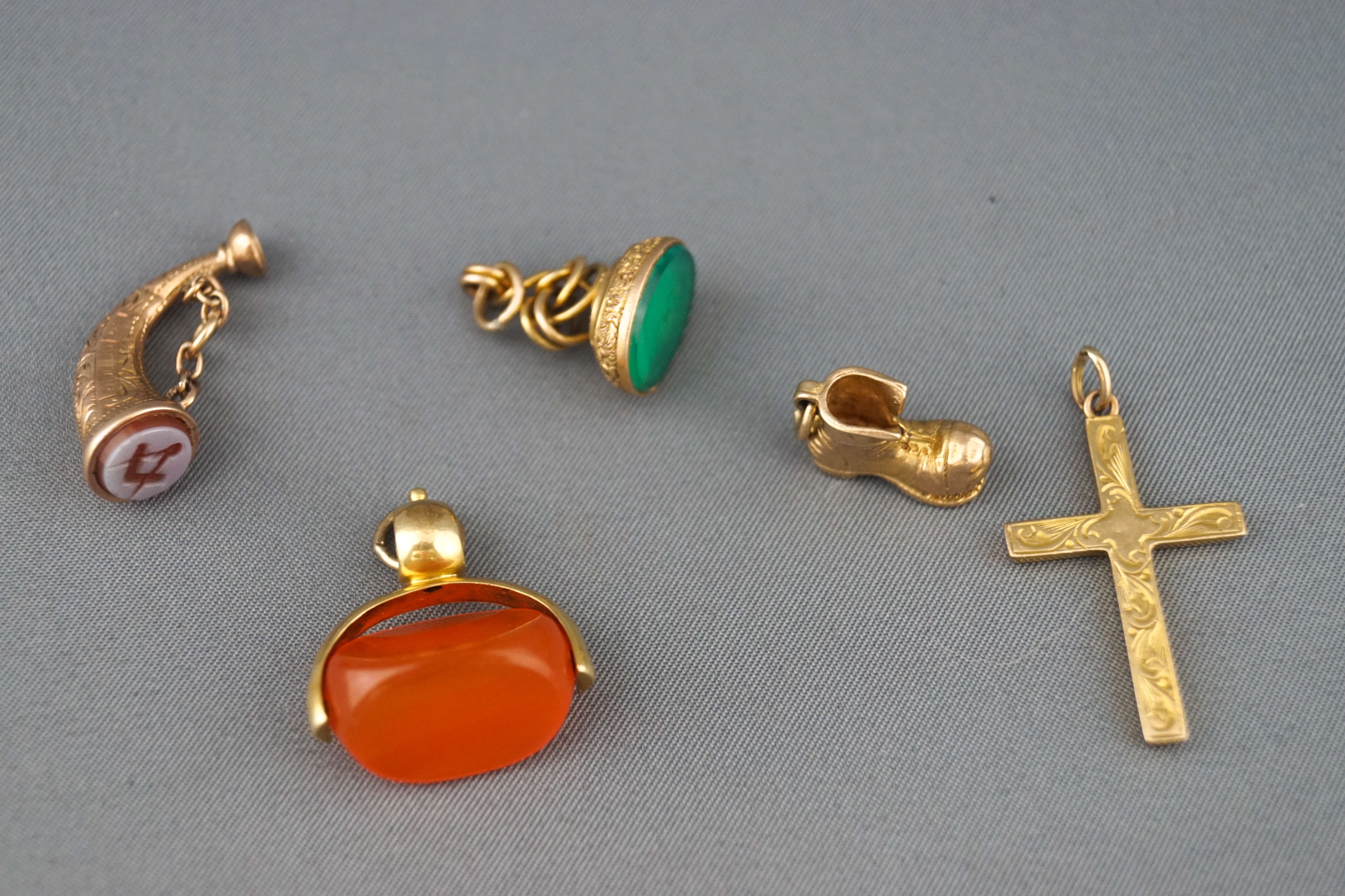 A selection of five gold charms to include an agate spinner, A masonic horn seal, a boot,